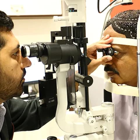 Eye doctor conducting an eye examination using a slit lamp on a patient.